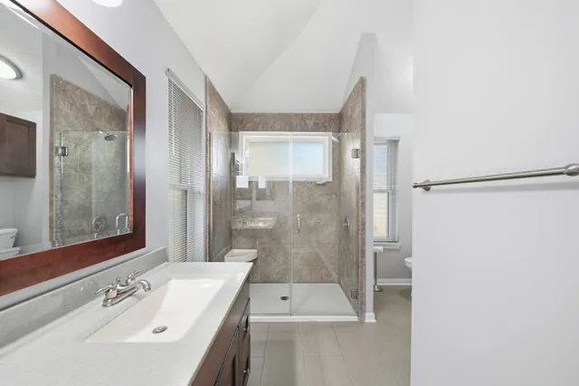 a bathroom with a shower a sink and a mirror