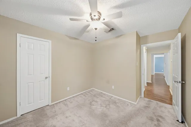 an empty room with fan and a ceiling fan