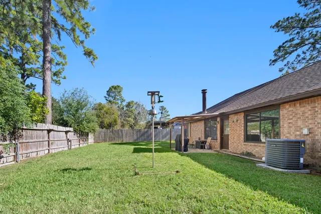 a view of a house with backyard and a tree