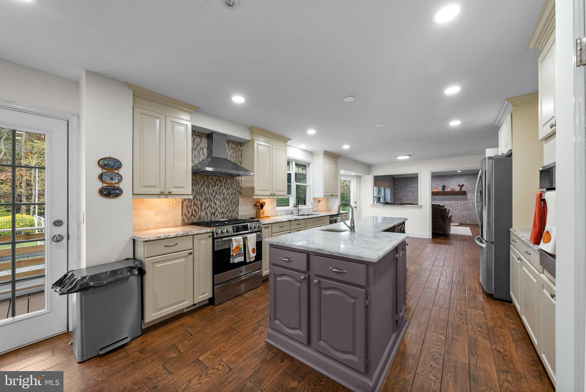 40 Doe Drive Hamilton, NJ 08620 - Photo 16 of 62 a kitchen with stainless steel appliances granite countertop a stove top oven a sink dishwasher and a refrigerator with wooden floor