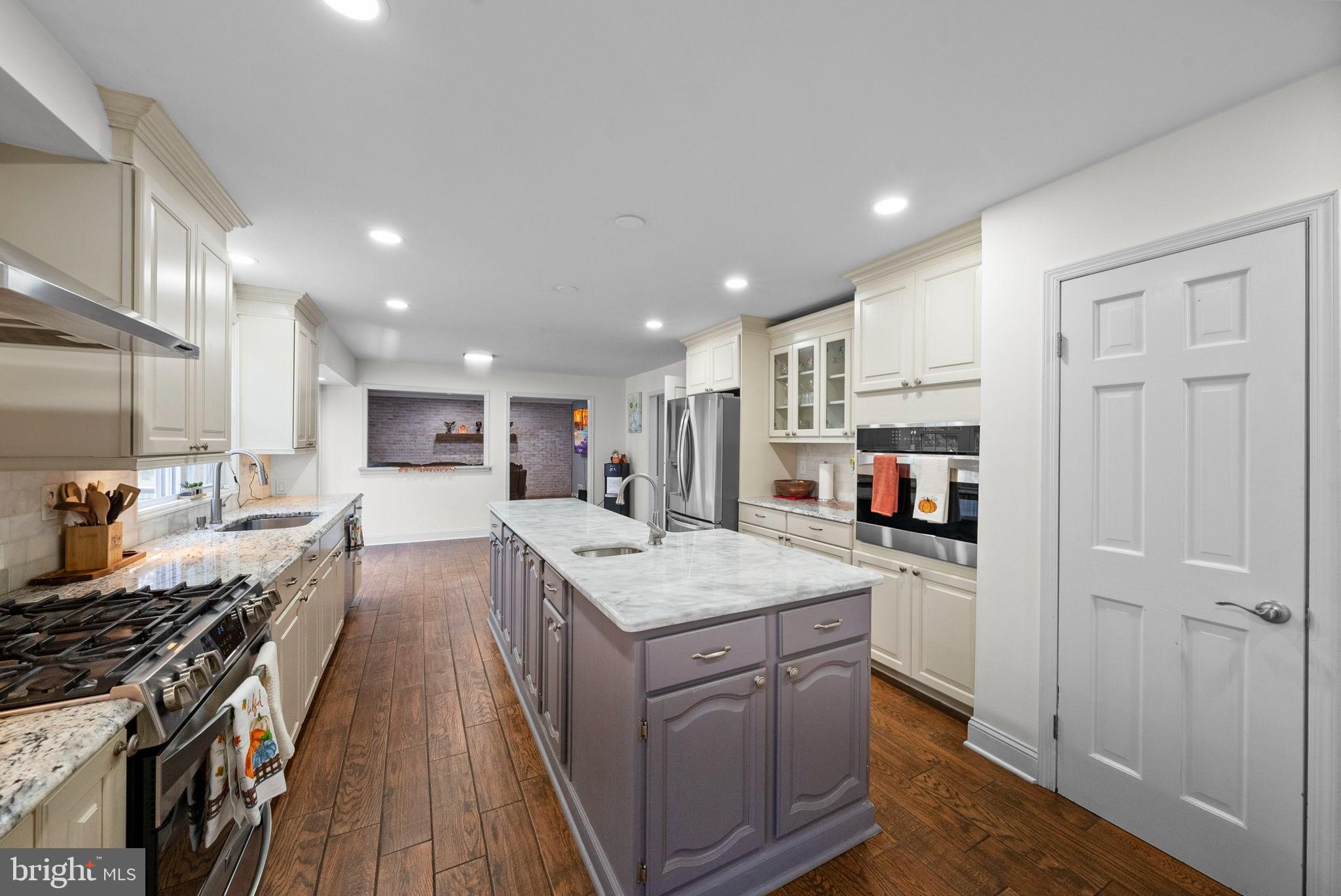 40 Doe Drive Hamilton, NJ 08620 - Photo 17 of 62 a kitchen with stainless steel appliances granite countertop a stove top oven a sink dishwasher and a refrigerator with wooden floor