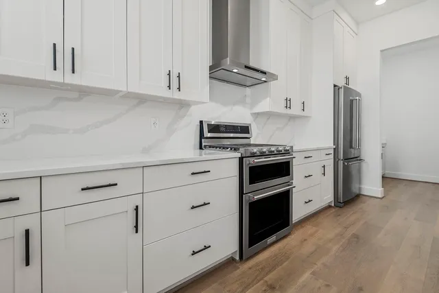 a kitchen with stainless steel appliances granite countertop a sink a stove and cabinets