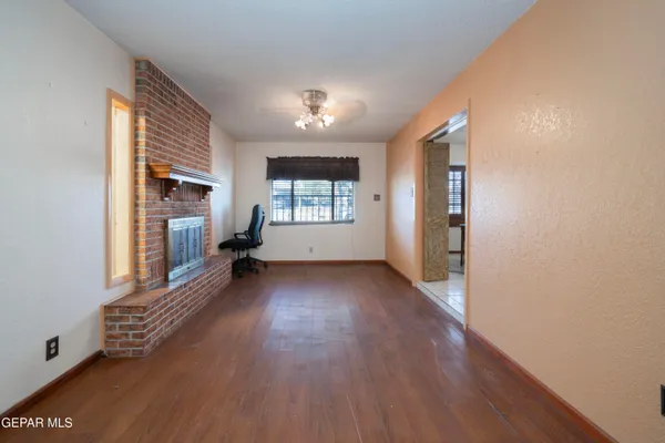 a view of a big room with wooden floor and windows