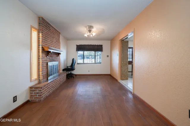 a view of a big room with wooden floor and windows