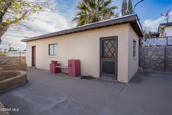 a backyard of a house with barbeque oven and furniture