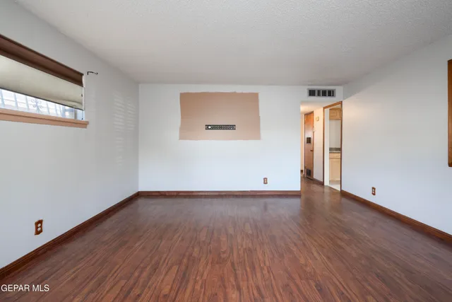 a view of an empty room and wooden floor