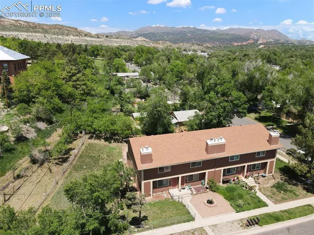 an aerial view of a house with a yard and mountain view in back