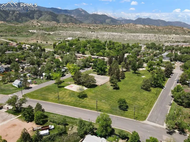 an aerial view of residential houses with outdoor space and trees