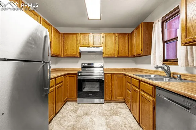a kitchen with stainless steel appliances granite countertop a refrigerator and a sink