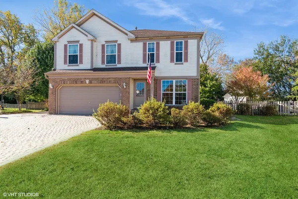 a front view of a house with a garden and yard