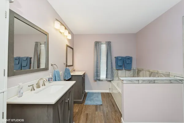 a en suite bathroom with a double vanity sink and a mirror