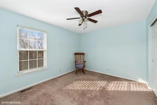 a view of a bedroom with a ceiling fan and a window