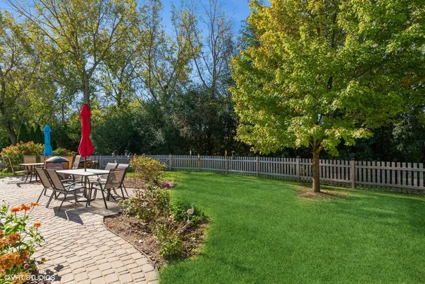 a view of house with backyard and furniture