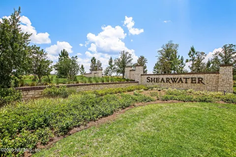 a view of a swimming pool with a yard and palm trees