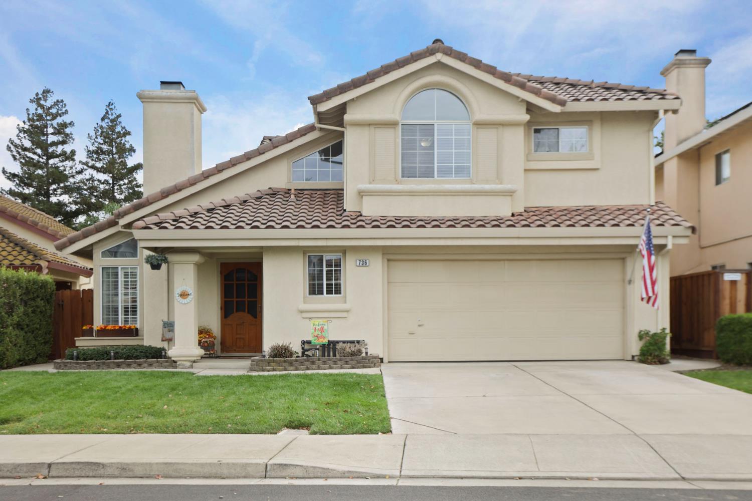 a view of a white house with a yard and large tree