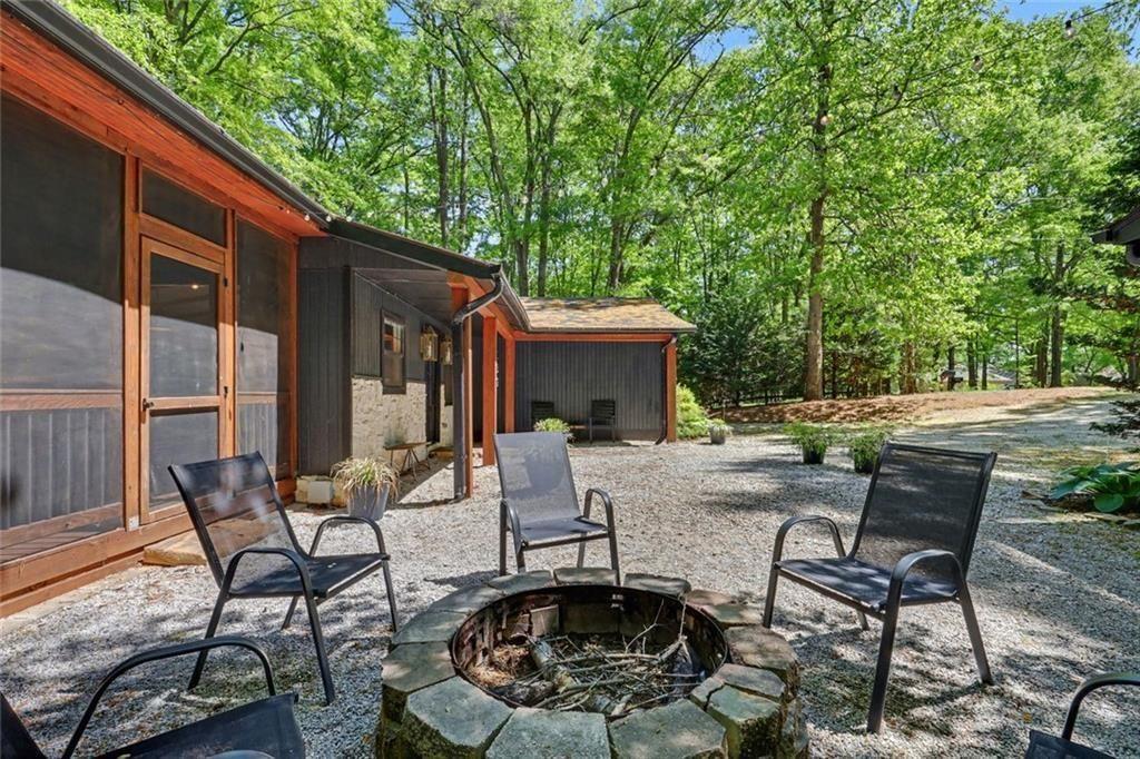 159 Manor Oak Trail Toccoa, GA 30577 - Photo 55 of 68 a view of a patio with table and chairs and floor to ceiling window and wooden fence