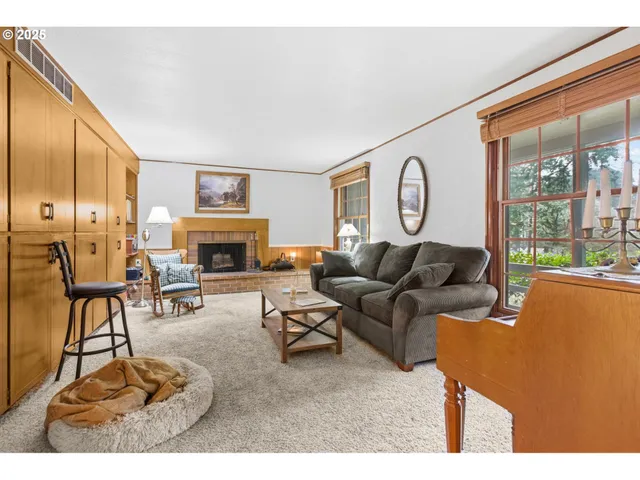 a living room with furniture a large window and a fireplace