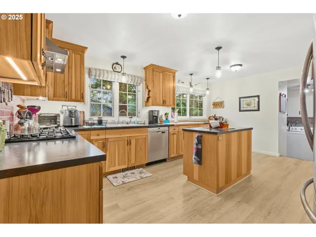 a kitchen with kitchen island granite countertop a sink cabinets and wooden floor