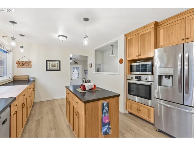 a kitchen with kitchen island a counter top space a sink stainless steel appliances and cabinets
