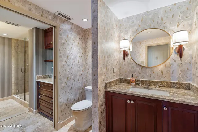 a bathroom with a granite countertop toilet sink and mirror