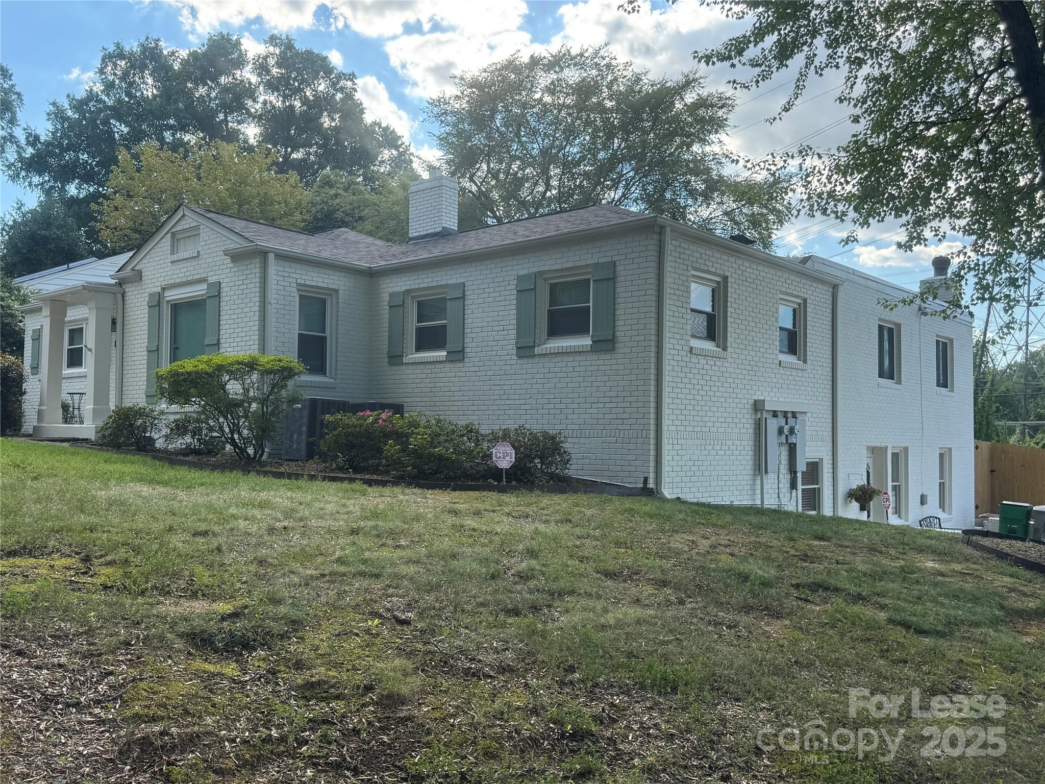 a house that has a tree in front of a white house