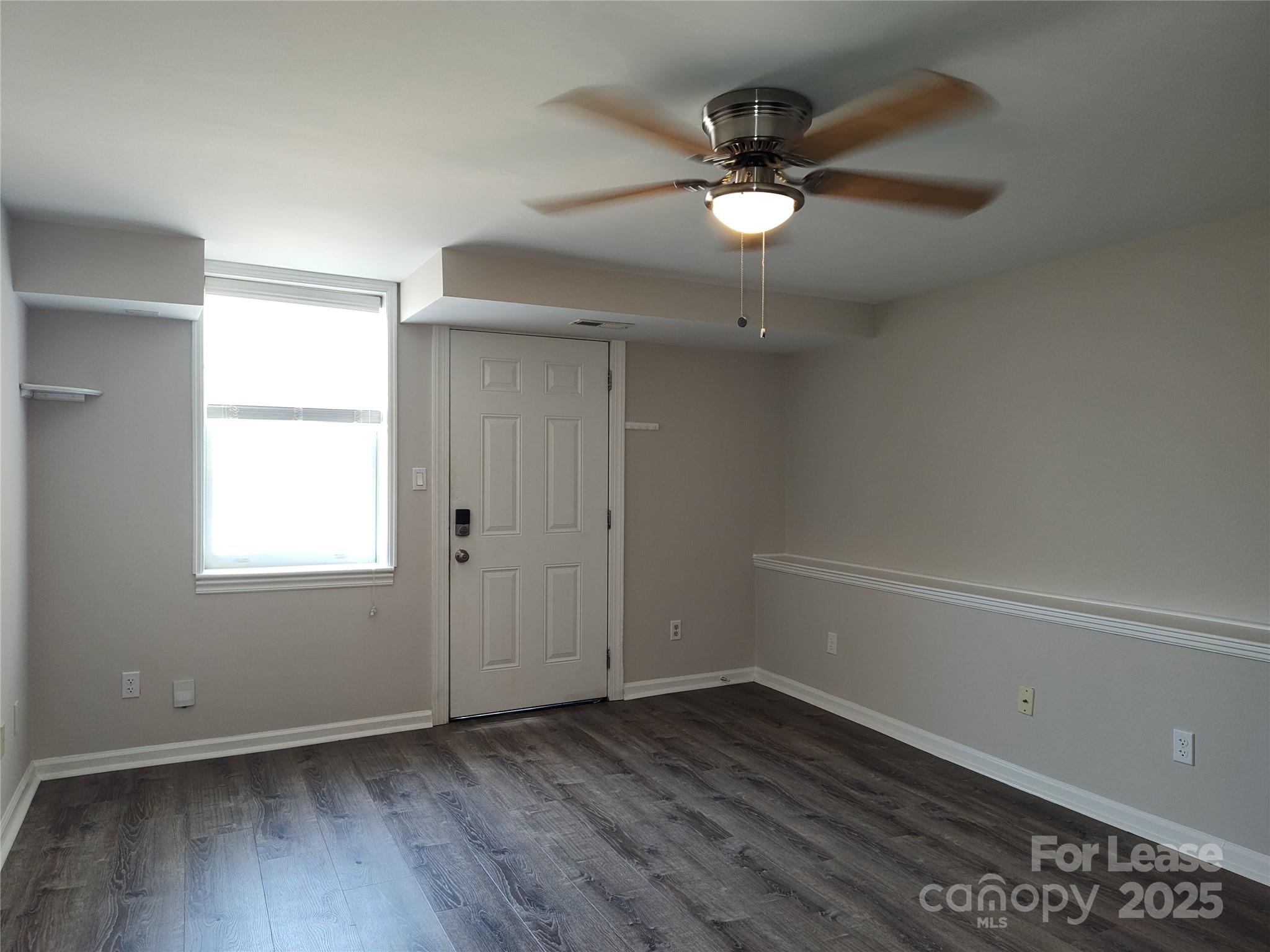 340 Hollis Road Charlotte, NC 28209 - Photo 12 of 21 an empty room with wooden floor fan and windows