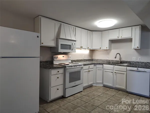 a kitchen with granite countertop cabinets stainless steel appliances and a sink