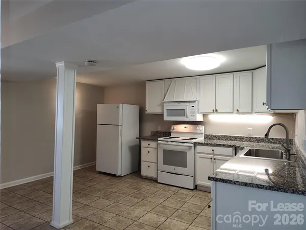 a kitchen with a stove top oven and refrigerator