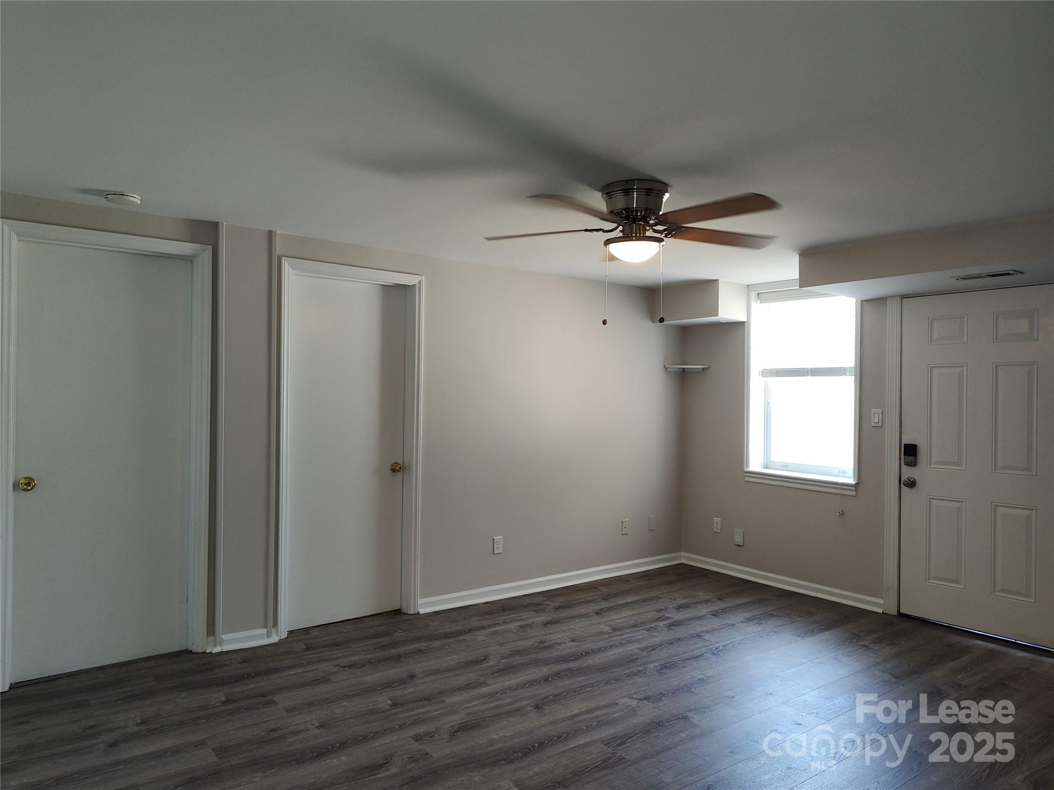 340 Hollis Road Charlotte, NC 28209 - Photo 10 of 21 an empty room with wooden floor and ceiling fan