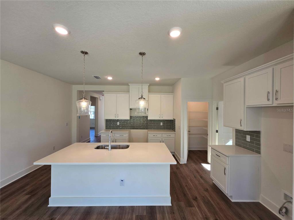 3352 Daybreak Run Loop Spring Hill, FL 34609 - Photo 2 of 15 a kitchen with a refrigerator a stove and white cabinets with wooden floor