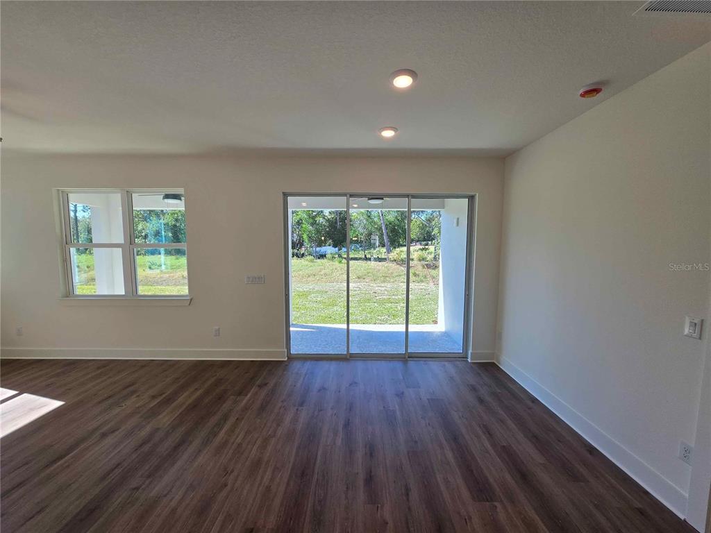 3352 Daybreak Run Loop Spring Hill, FL 34609 - Photo 4 of 15 a view of an empty room with wooden floor and a window