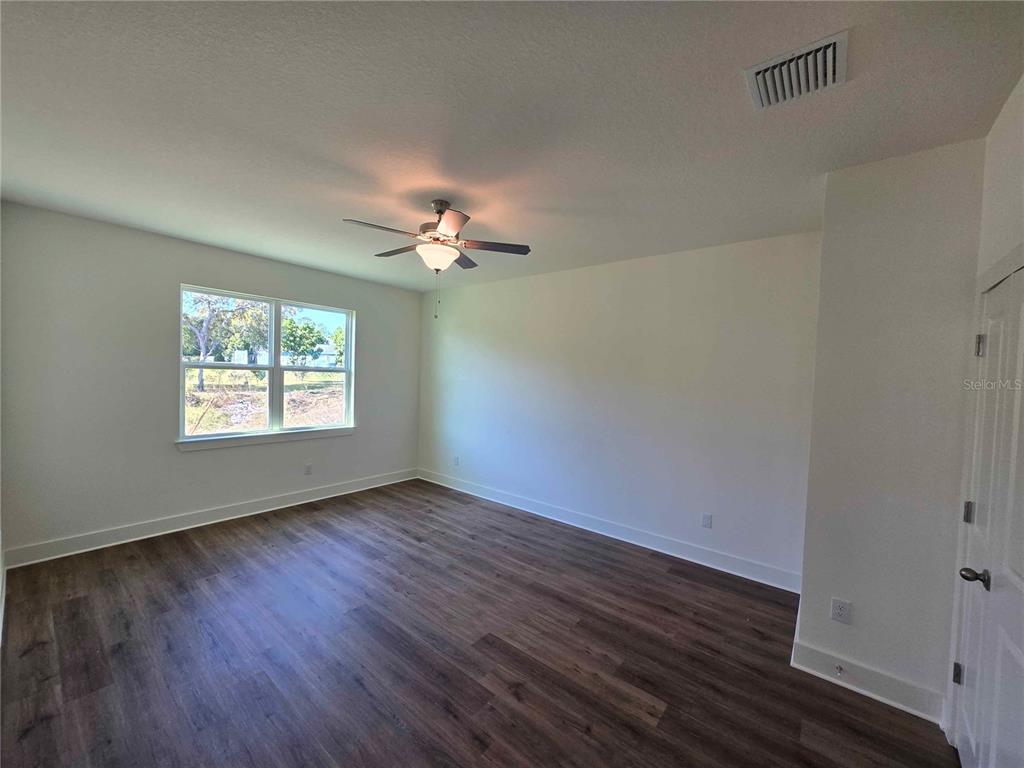 3352 Daybreak Run Loop Spring Hill, FL 34609 - Photo 6 of 15 a view of an empty room with wooden floor and a window