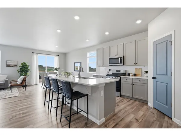 a open kitchen with kitchen island white cabinets and stainless steel appliances