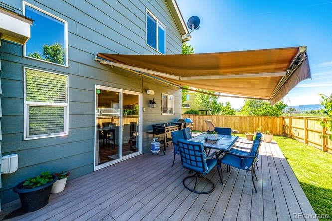 2016 West Ashwood Place Highlands Ranch, CO 80129 - Photo 15 of 40 a view of a patio with table and chairs potted plants with wooden floor and fence