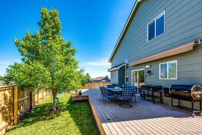 2016 West Ashwood Place Highlands Ranch, CO 80129 - Photo 20 of 40 a view of backyard with seating space and trees in the background