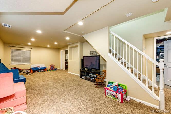 2016 West Ashwood Place Highlands Ranch, CO 80129 - Photo 33 of 40 a view of a hallway with a livingroom with furniture and a flat screen tv