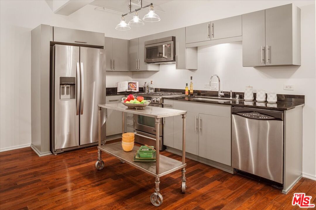 510 South Hewitt Street, Unit 106 Los Angeles, CA 90013 - Photo 4 of 26 a kitchen with wooden cabinets and refrigerator