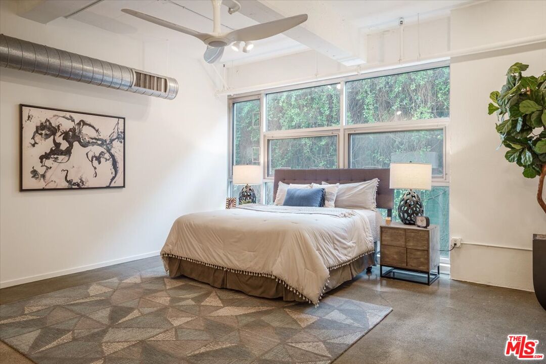 510 South Hewitt Street, Unit 106 Los Angeles, CA 90013 - Photo 9 of 26 a bedroom with a large bed and a painting on the wall