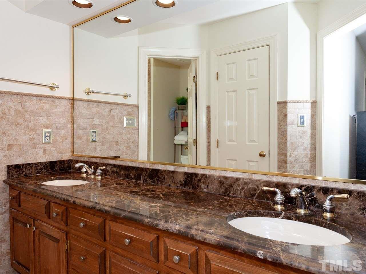 701 Presnell Court Raleigh, NC 27615 - Photo 15 of 24 a bathroom with a granite countertop sink and a mirror