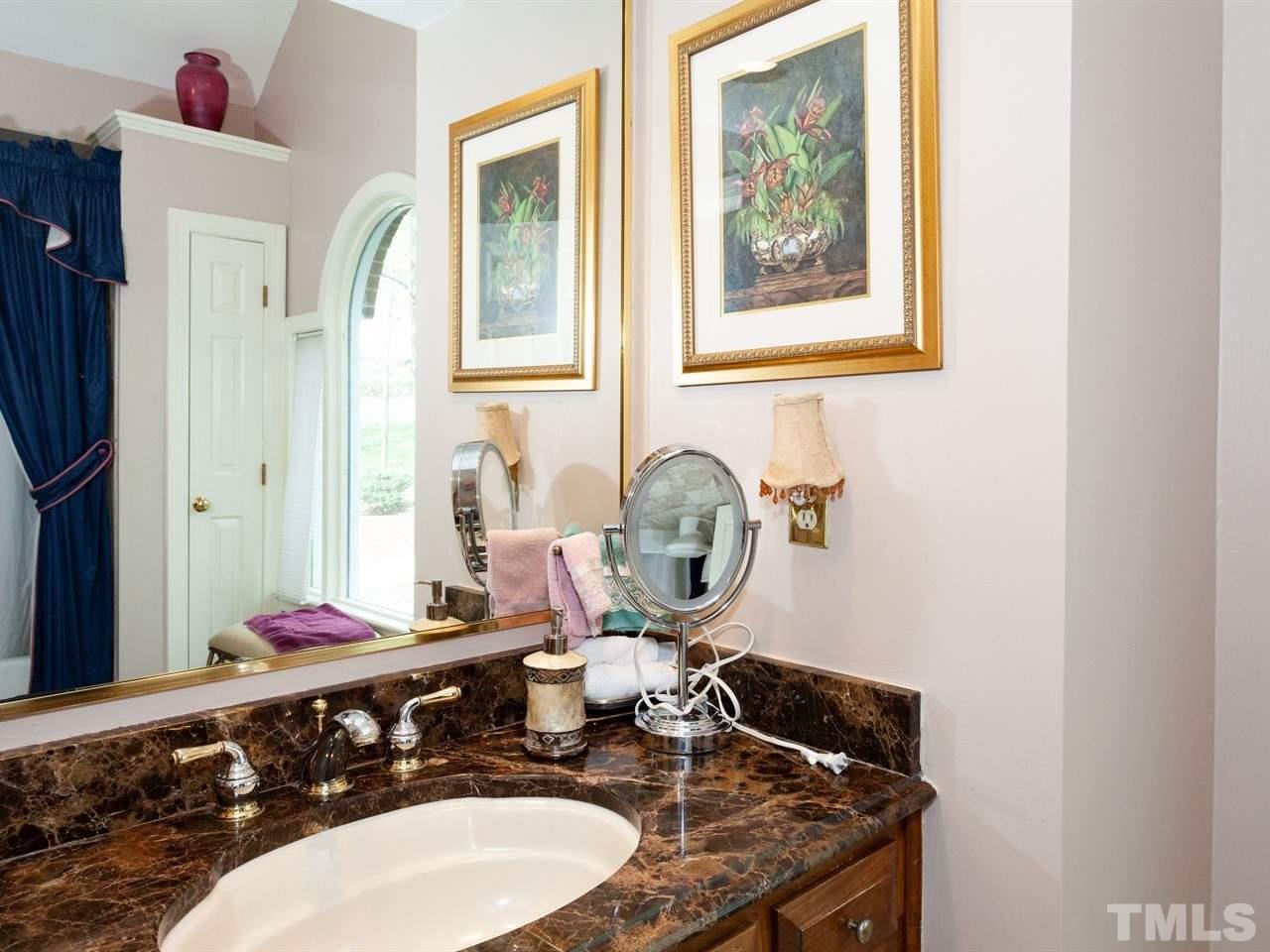 701 Presnell Court Raleigh, NC 27615 - Photo 20 of 24 a bathroom with a granite countertop sink and a mirror