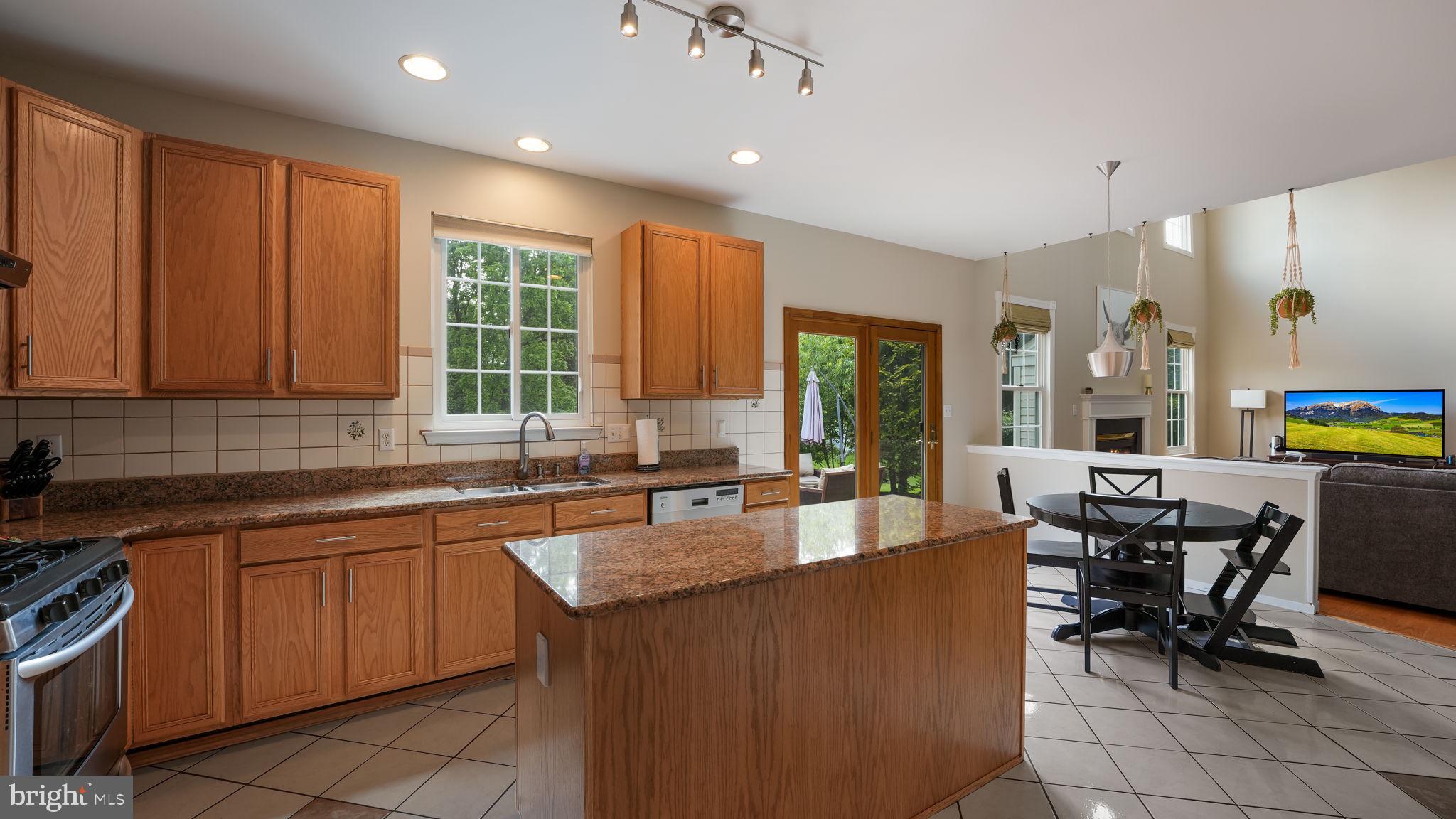 408 Longleaf Drive Perkasie, PA 18944 - Photo 12 of 36 a kitchen with stainless steel appliances granite countertop sink stove and table