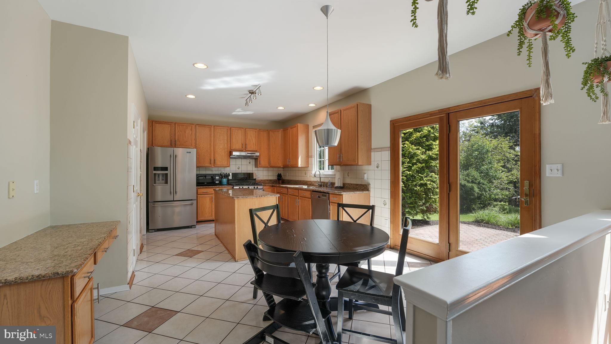 408 Longleaf Drive Perkasie, PA 18944 - Photo 10 of 36 a kitchen with stainless steel appliances granite countertop a stove a refrigerator a kitchen island a dining table and chairs