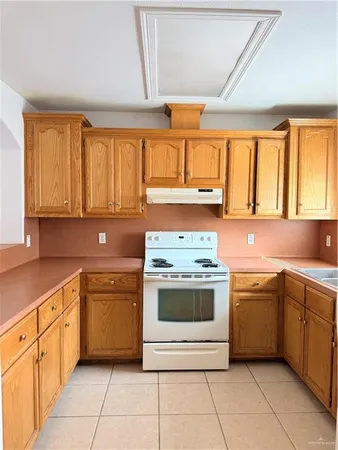 a kitchen with a stove sink and cabinets