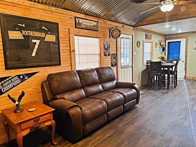 a living room with furniture a ceiling fan and a wooden floor