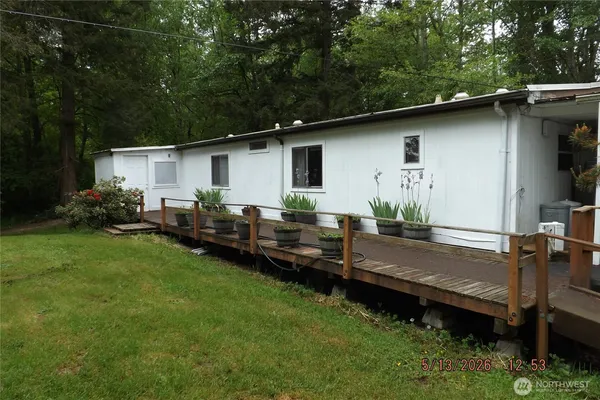 a backyard of a house with wooden deck table and chairs