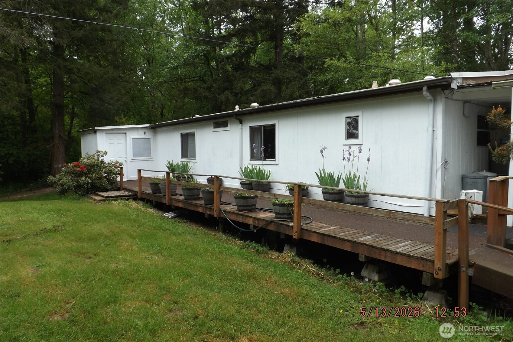 a backyard of a house with wooden deck table and chairs