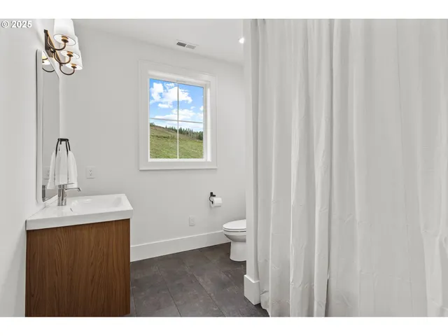 a bathroom with a toilet a sink a vanity and mirror