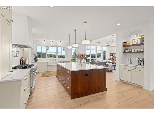 a large kitchen with stainless steel appliances kitchen island granite countertop a large counter top and a stove