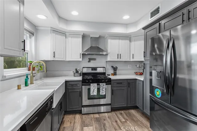 a kitchen with stainless steel appliances granite countertop a stove a refrigerator and a sink