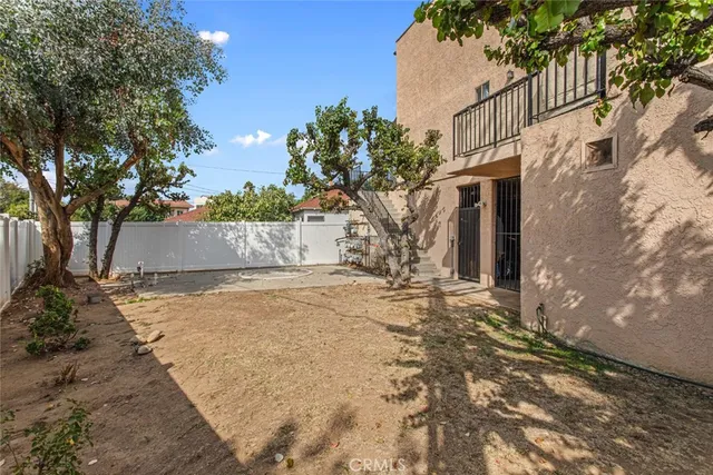 a view of a brick house with a small yard and plants